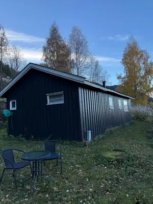 a black building with a table in front of it at Lite hus i Vestre Slidre in Slidre