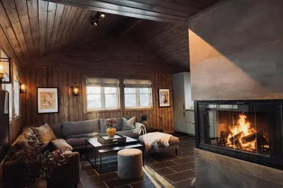 a living room with a couch and a fireplace at Stylish cabin near Hemsedal ski resort, 200 m to slopes & lift in Hemsedal