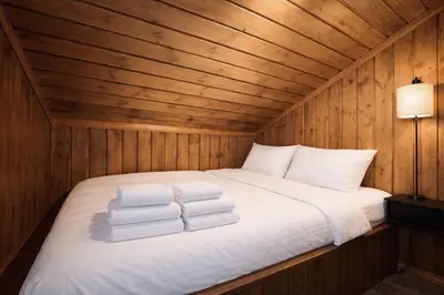 a bed in a wooden room with towels on it at Stylish cabin near Hemsedal ski resort, 200 m to slopes & lift in Hemsedal