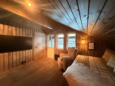 a bedroom with a bed and a tv on the wall at Stylish cabin near Hemsedal ski resort, 200 m to slopes & lift in Hemsedal