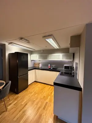 a kitchen with a black refrigerator and a table at Modern apartment in central Trondheim in Trondheim