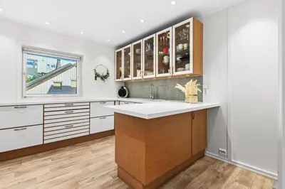 a kitchen with white walls and wooden cabinets at Konsul Moes Gate 4 in Verdal