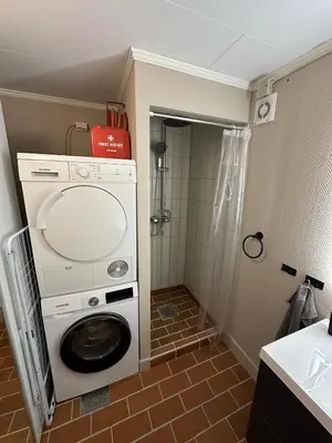 a washer and dryer in a small bathroom at Apartment centrally with garage and terrace in Ålesund