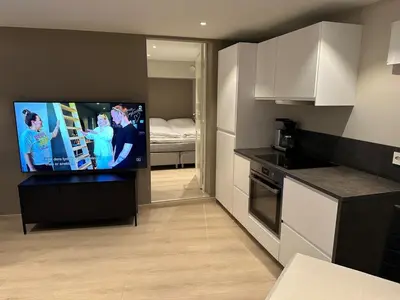 a kitchen with a flat screen tv in a room at Apartment centrally with garage and terrace in Ålesund