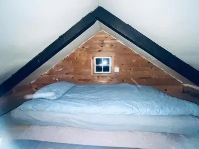 a bed in a wooden room with a window at Innvik Hytte Anna in Stryn