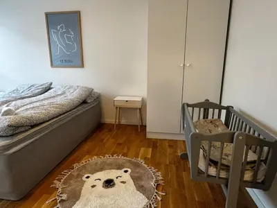 a bedroom with a crib and a bear rug at Big apartment - Prime Location - Middle of Voss in Vossevangen