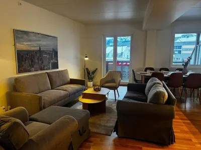 a living room with couches and a dining room with a table at Big apartment - Prime Location - Middle of Voss in Vossevangen