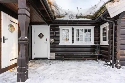 a log cabin with a bench in the snow at Trysilfjell nord 590 by Vacation Trysil in Trysil