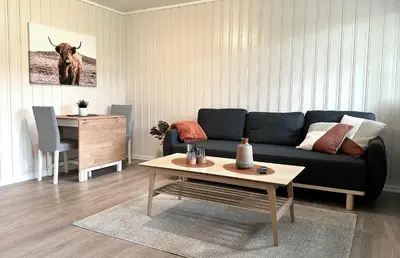 a living room with a blue couch and a table at Apartment centrally located in Bud in Bud