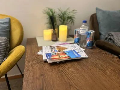a table with magazines and drinks on top of it at Riverside studioapartment 100m from trainstation! in Trondheim