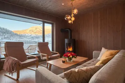 a living room with a couch and chairs and a fireplace at Modern ski-in-ski-out apartment in Hemsedal in Hemsedal