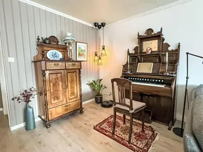 an old piano and a chair in a room at Holiday Home Høyanger Panorama by Interhome in Høyanger