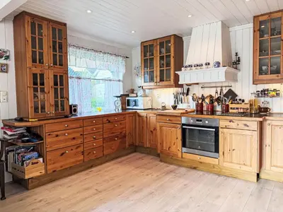 a kitchen with wooden cabinets and a stove top oven at Holiday Home Høyanger Panorama by Interhome in Høyanger