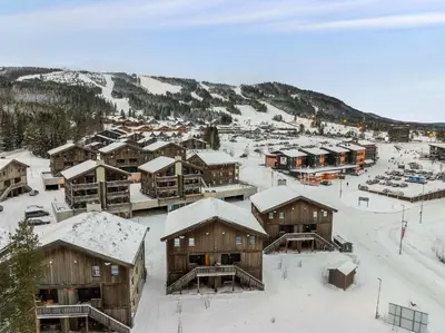 a town with snow covered buildings and a mountain at Trysiltunet 28A by Vacation Trysil in Trysil