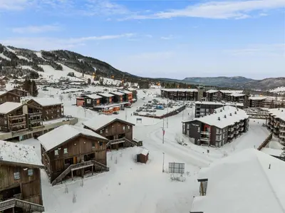 a town covered in snow with buildings and mountains at Trysiltunet 28A by Vacation Trysil in Trysil