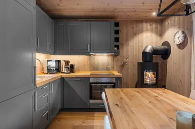 a kitchen with gray cabinets and a wooden table at Trysiltunet 28A by Vacation Trysil in Trysil
