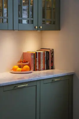 a counter with a plate of oranges and books at Charming apartment with balcony and view! in Ålesund
