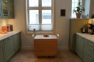 a kitchen with a table with a bowl of fruit on it at Charming apartment with balcony and view! in Ålesund