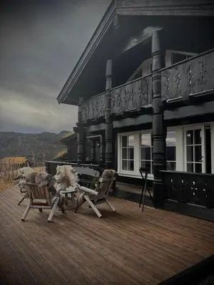 two dogs sitting on the deck of a house at Great mountain cabin with 12 beds in Vågsli