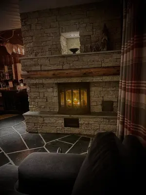 a stone fireplace in a living room with a couch at Great mountain cabin with 12 beds in Vågsli