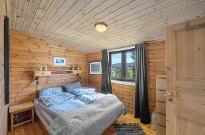 a bedroom with a bed in a wooden room at Cabin in Hovden with Beautiful views in Bykle