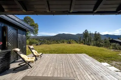 two chairs on a deck with a view of a field at Cabin in Hovden with Beautiful views in Bykle