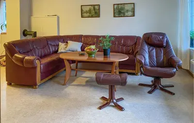 a living room with a brown leather couch and a table at Amazing Apartment In Verma With Wifi in Verma