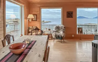 a living room with a table and large windows at 3 Bedroom Stunning Home In Tansøy in Tansøy