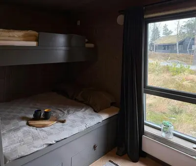 a bed with two mugs on it next to a window at Cabin With Sauna At Norefjell in Noresund