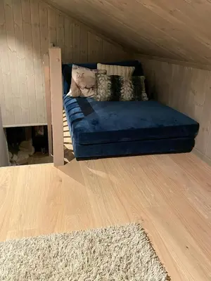 a blue couch in a room with a wooden floor at Cabin With Sauna At Norefjell in Noresund