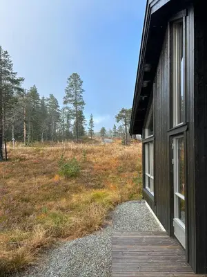 a door to a house with a field behind it at Cabin With Sauna At Norefjell in Noresund