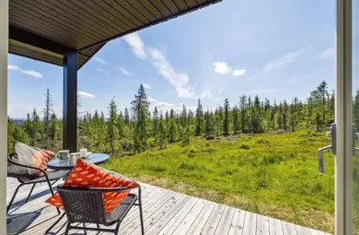 a patio with a table and chairs on a deck at Family Cabin BUDOR - 60 MIN FROM OSL - Alpine Cross Country Skiing in Løten