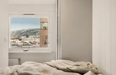 a bedroom with a bed and a window with a view at Modern and cozy apartment ONLY 5 minutes from City Center in Bergen
