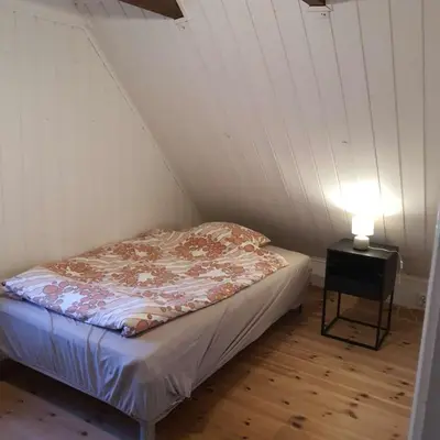 a small bed in a room with a lamp at Great apartment overlooking Bergen in Bergen