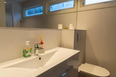 a bathroom with a white sink and a toilet at Spacious Apartment - City Center in Stryn