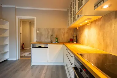 a kitchen with white cabinets and a sink at Spacious Apartment - City Center in Stryn