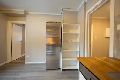 a kitchen with a stainless steel refrigerator and shelves at Spacious Apartment - City Center in Stryn