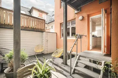 a balcony with a wooden bench and a door at Stylish 2BR with Patio and Smart TV - 10 min to Bryggen in Bergen