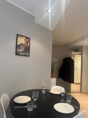 a dining room with a black table and white chairs at Stylish 2BR with Patio and Smart TV - 10 min to Bryggen in Bergen