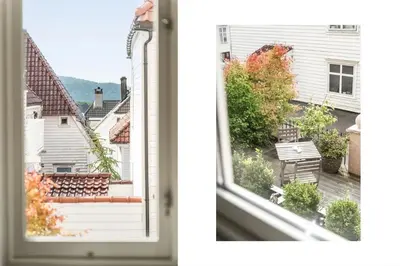 an open window with a view of a house at Stylish 2BR with Patio and Smart TV - 10 min to Bryggen in Bergen