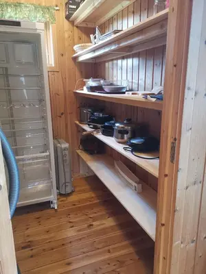 a kitchen with wooden walls and shelves with pots and pans at Åsrud seter i Jotunheimen in Vaga