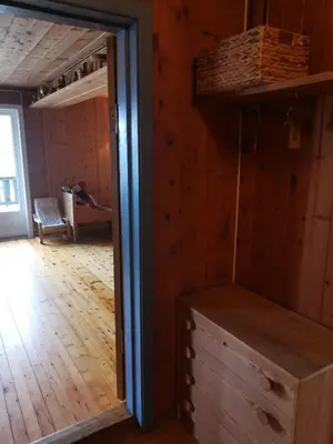 a room with a wooden floor and a closet with a mirror at Åsrud seter i Jotunheimen in Vaga