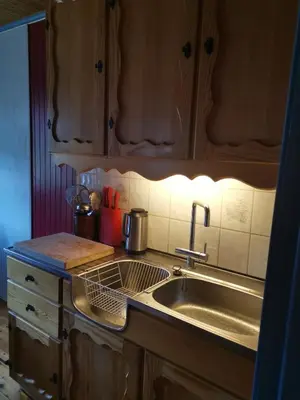 a kitchen with a stainless steel sink and wooden cabinets at Åsrud seter i Jotunheimen in Vaga