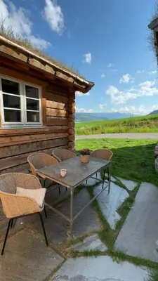 a table and chairs on a patio outside of a cabin at Gunhild-stugu i Jotunheimen