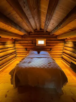 a bed in a wooden room with a window at Gunhild-stugu i Jotunheimen