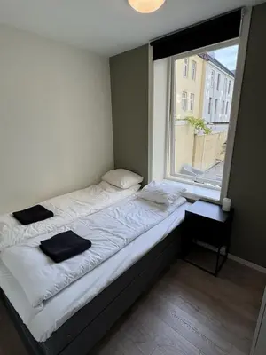 a bed in a room with a large window at Perfect central apartment Trondheim in Trondheim