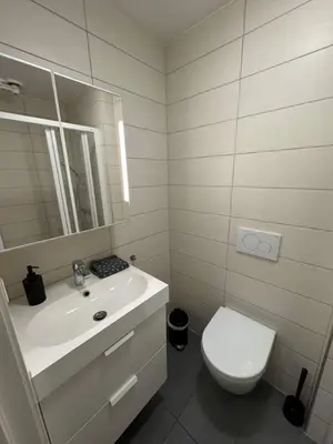 a white bathroom with a sink and a toilet at Perfect central apartment Trondheim in Trondheim