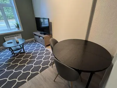 a living room with a table and a tv at Perfect central apartment Trondheim in Trondheim