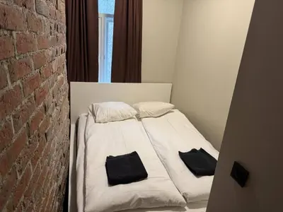 a white bed with two black pillows on it at Modern and central apartment in Trondheim in Trondheim