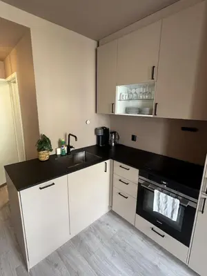 a kitchen with white cabinets and a black counter top at Modern and central apartment in Trondheim in Trondheim